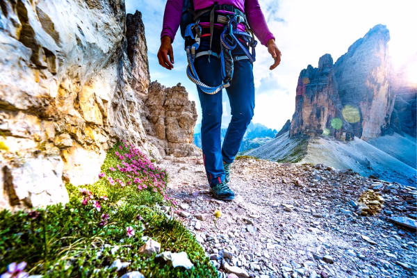 Pessoa caminhando nas montanhas com equipamento de escalada.