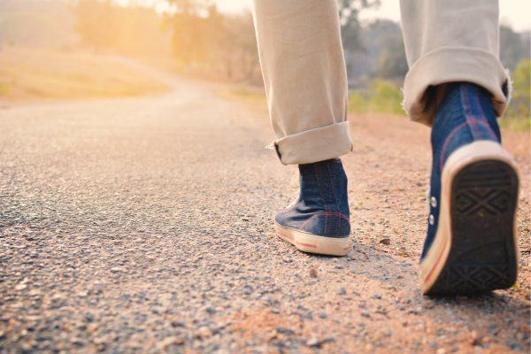 Foto de alguém caminhando com ênfase nos sapatos