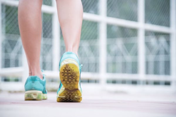 Mulher caminhando com sapatos para corrida